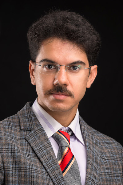 Hamidreza Omidbakhsh portrait. black background, photo with tie and eye glasses with perfect lighting